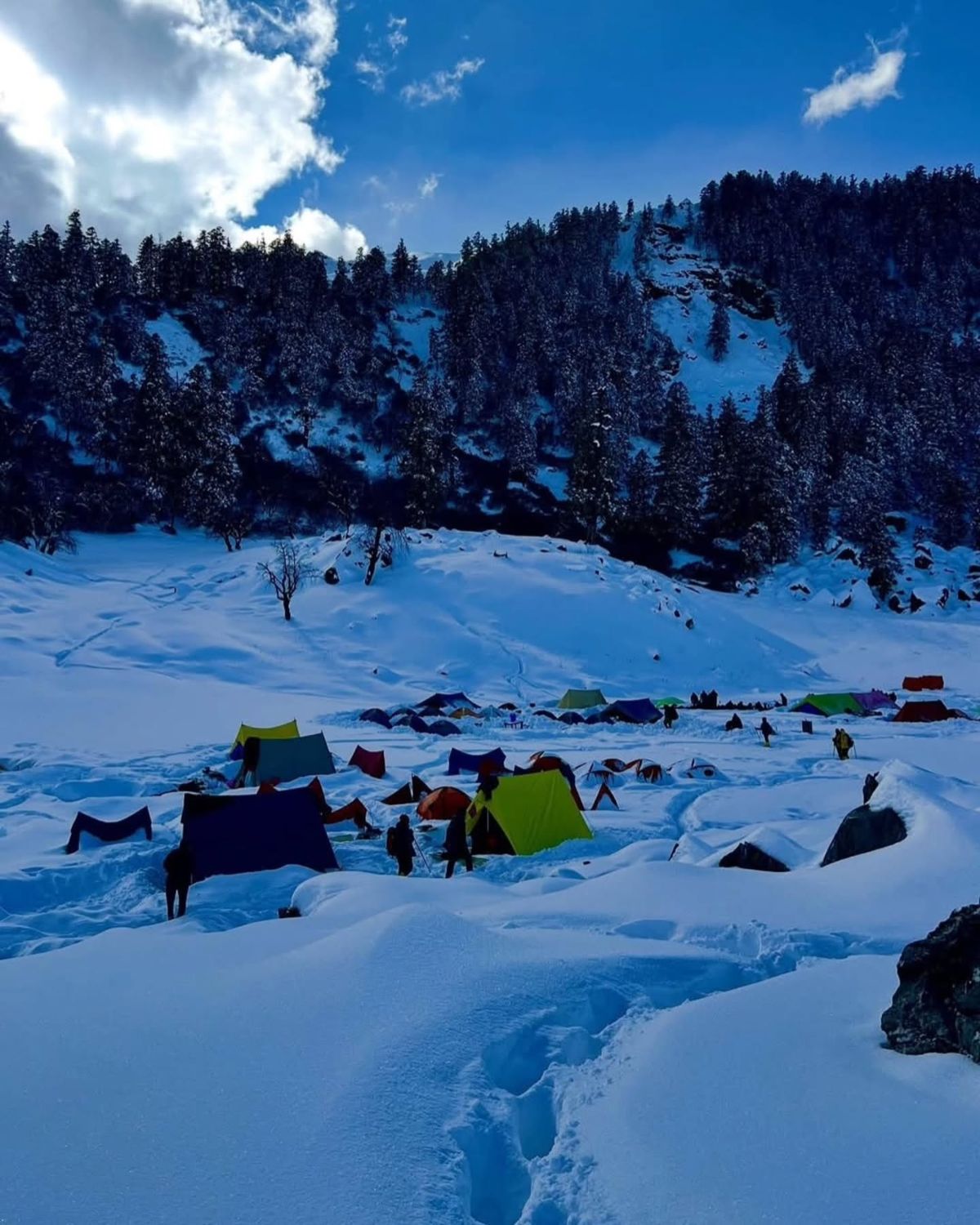 Colourful tents at Kedarkantha base camp in deep snow