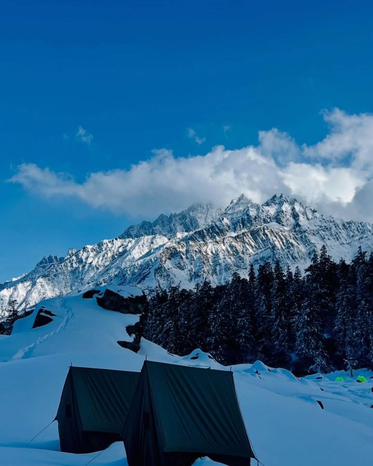 Tents in the snow beneath a mountain