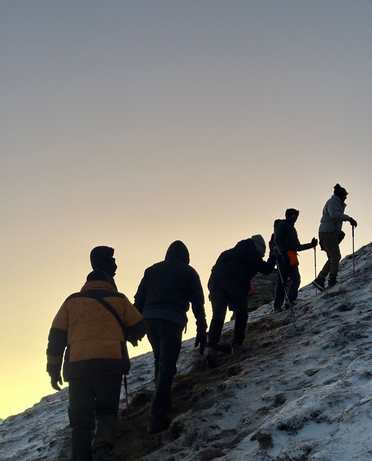 Trekkers silhouetted against the dawn on the summit ridge