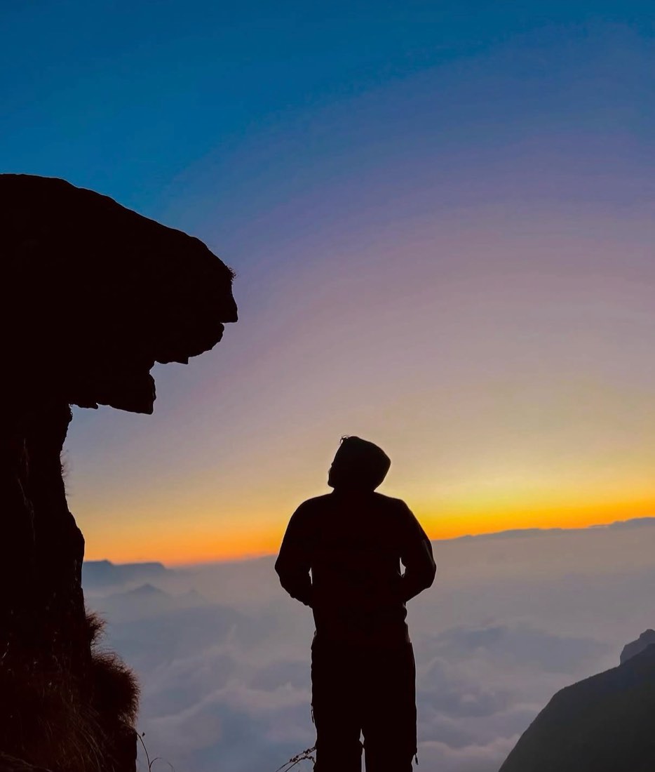 Silhouette at dawn above the clouds at Kolukkumalai