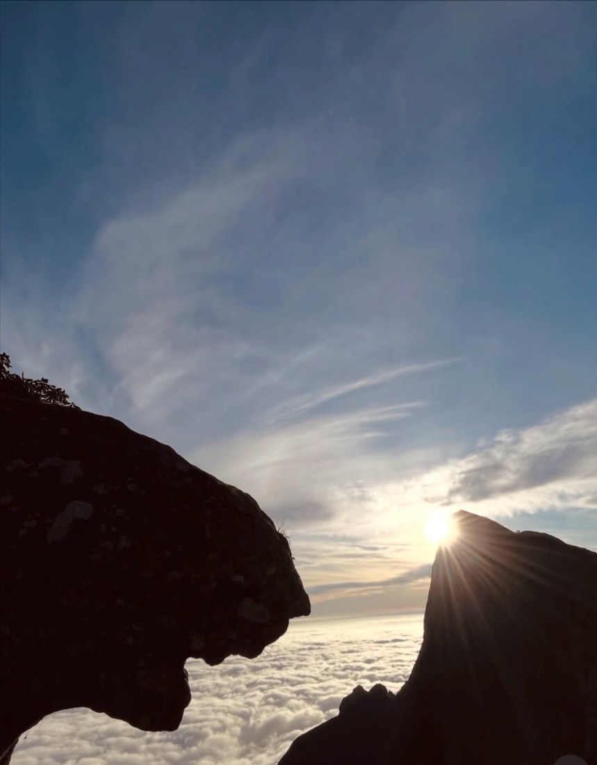 Sunbeams breaking over the sea of cloud at dawn