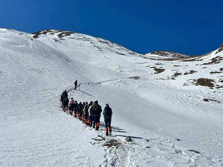 A line of trekkers on a snowy slope