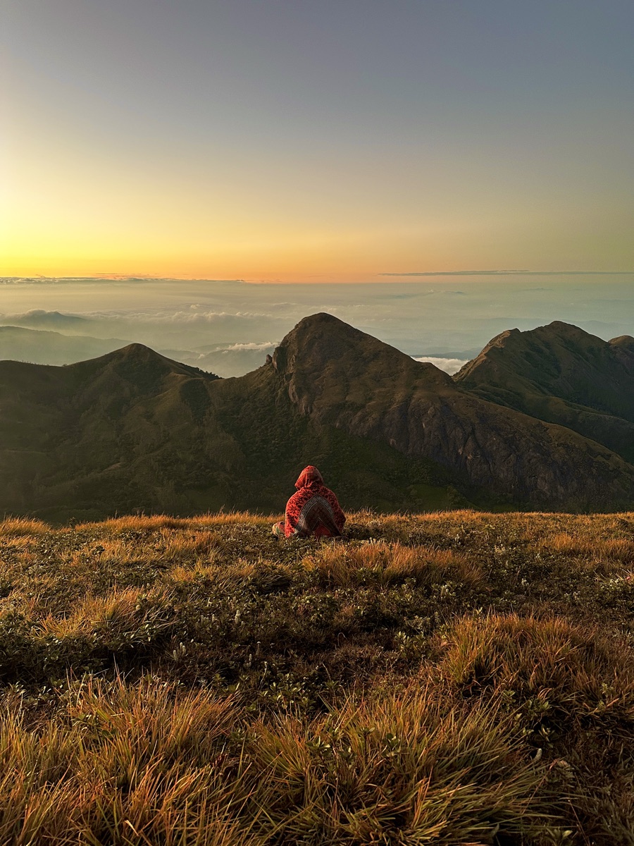 A trekker at the Meeshapulimala summit at sunrise